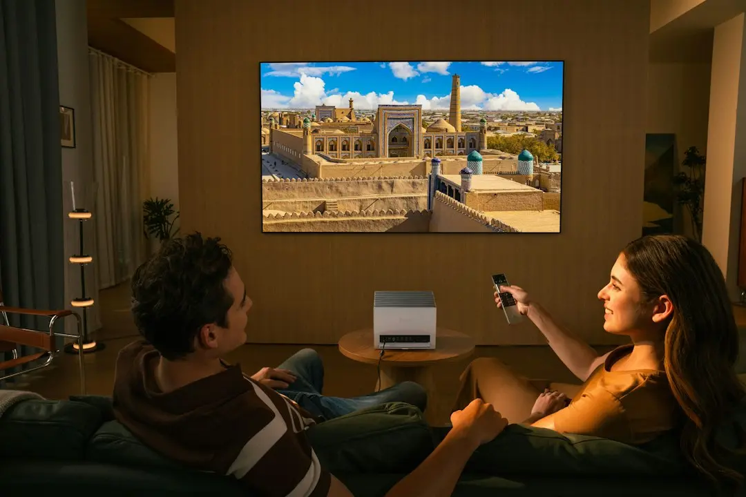 Una pareja ve la televisión en el sofá del salón por la noche, como con IPTV Fiesta
